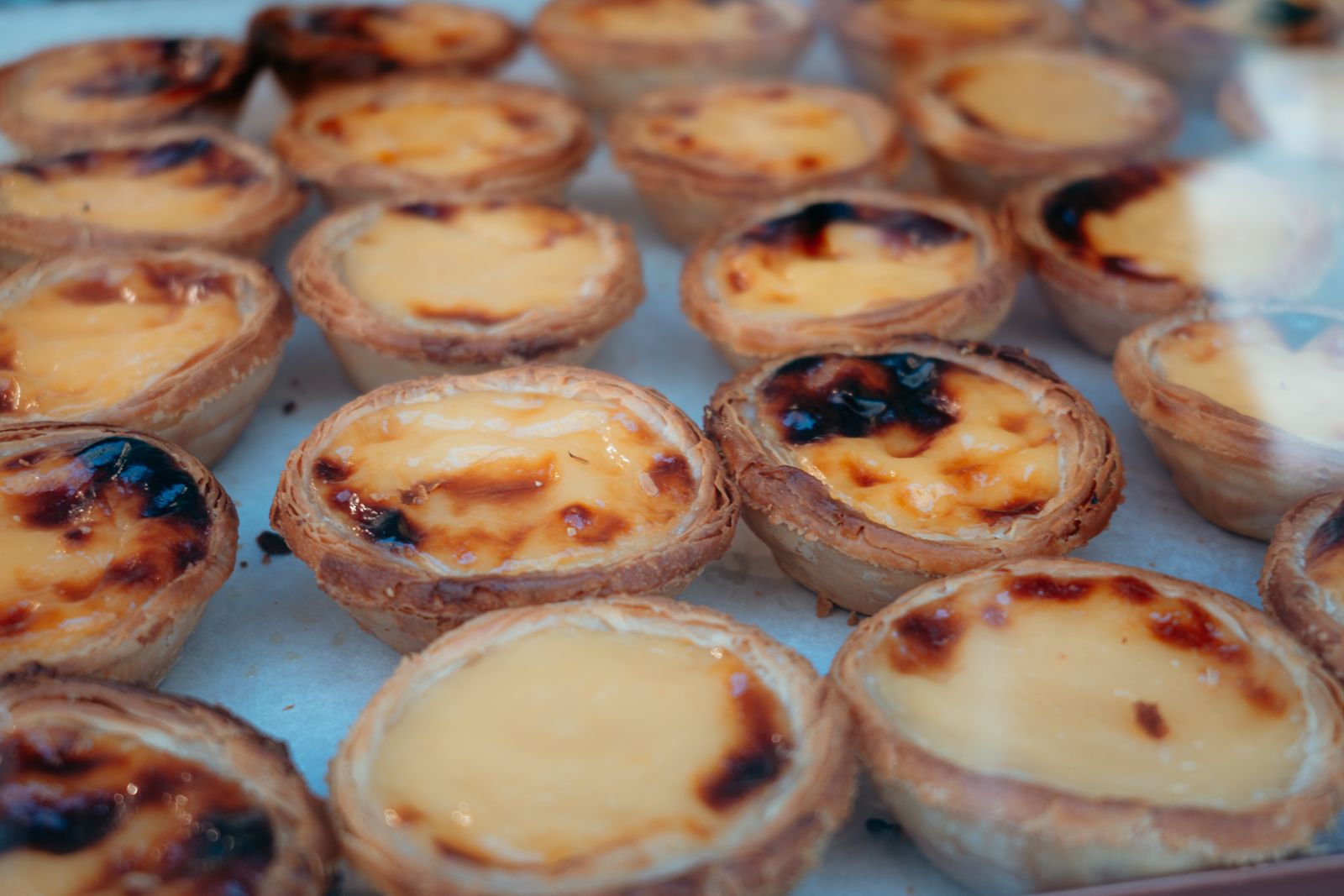 Una bandeja de pasteles de nata portugueses con la superficie ampollada y caramelizada. Foto de Markus Winkler en Pexels.