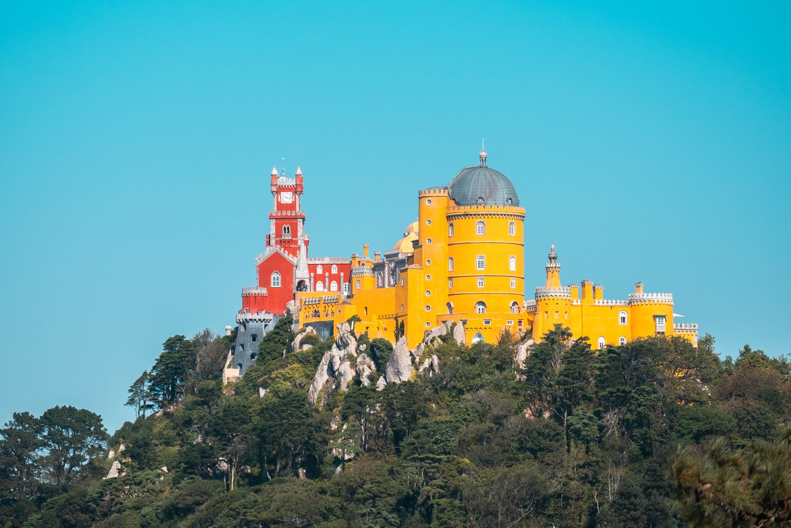 The red and yellow towers of the Pena Palace above the forests of Sintra. Photo by Mo Eid on Pexels.