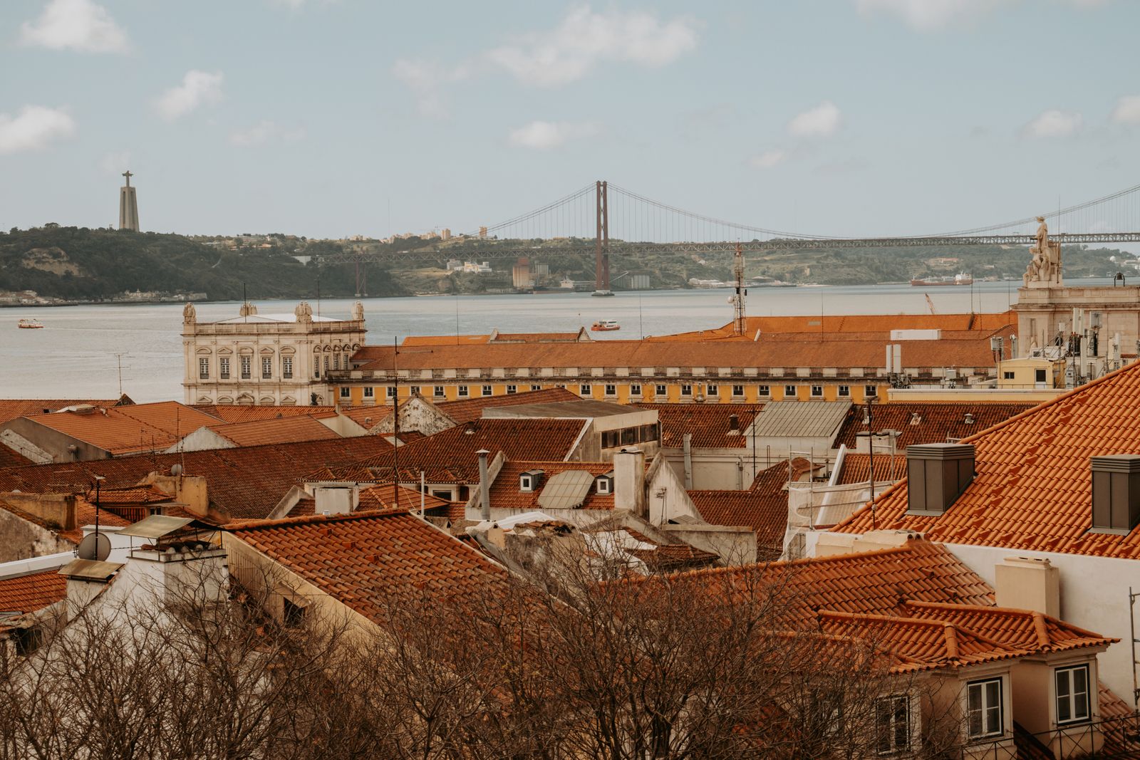 Lisbon rooftops with the 25 de Abril bridge and the Tagus beyond. Photo by Rıdvan Yıldırım on Pexels.