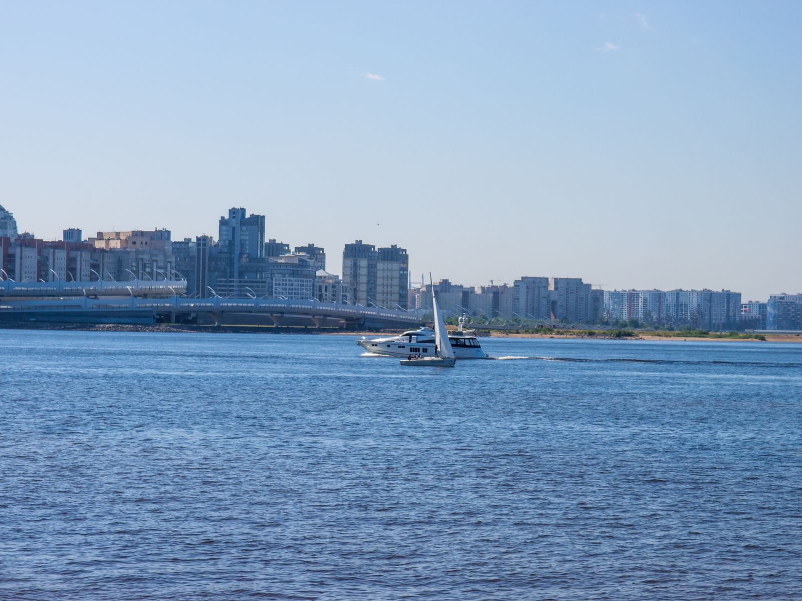 A boat on a wide river with the city on the far bank. Photo by paul on Pexels.