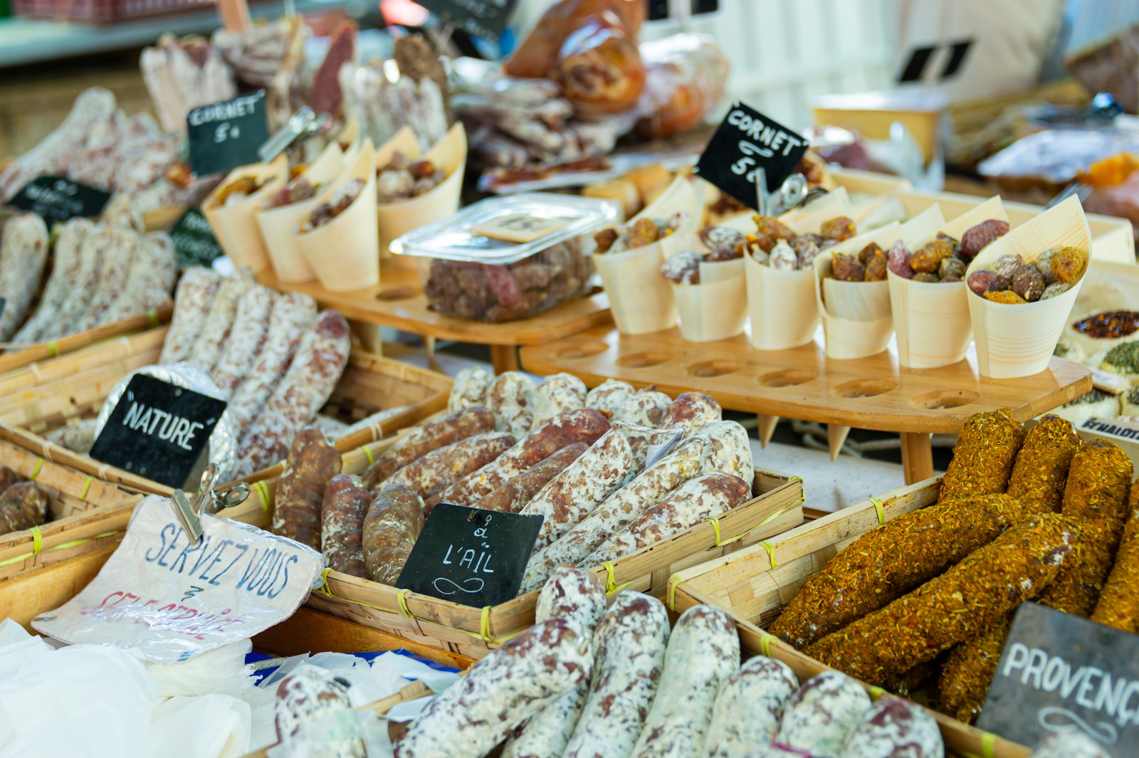 A Provençal market stall of cured sausages and snacks with hand-chalked signs. Photo by Terry Granger on Unsplash.