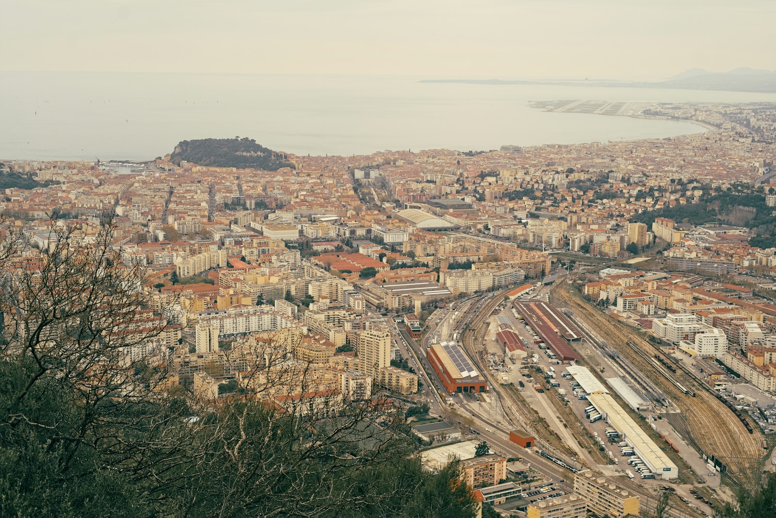 An aerial view over Nice with the coastal railway and the curve of the bay beyond. Photo by Amadeus Ménestrel on Unsplash.