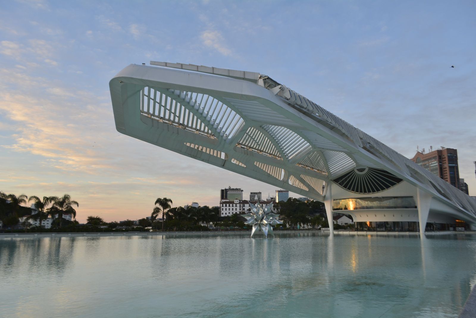 The Museu do Amanhã on Rio's waterfront reflected in the water at dusk. Photo by Talitha Gonçalves on Pexels.