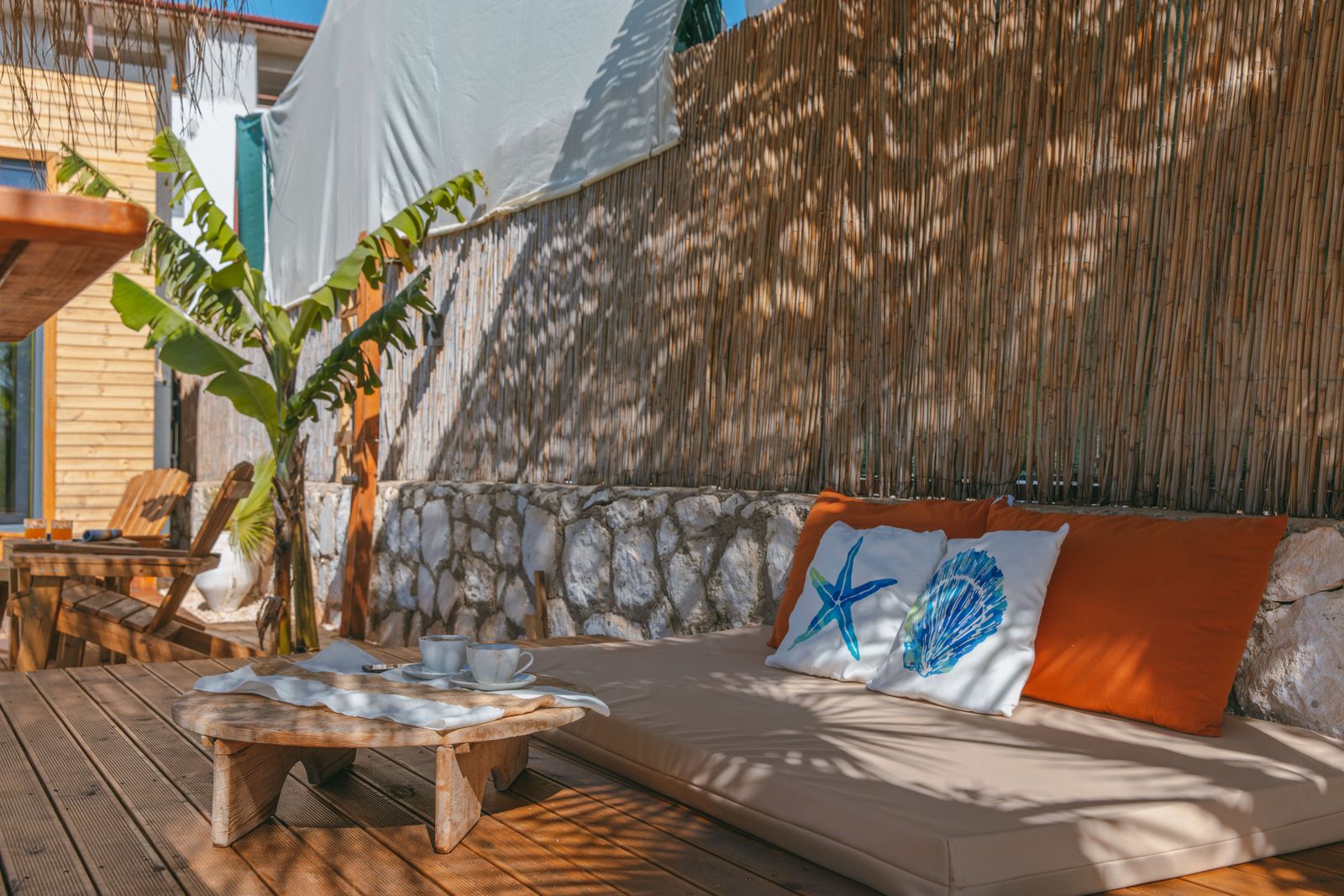 A sunlit terrace with tropical planting and low seating, set up for a long afternoon. Photo by Ahmet ÇÖTÜR on Pexels.