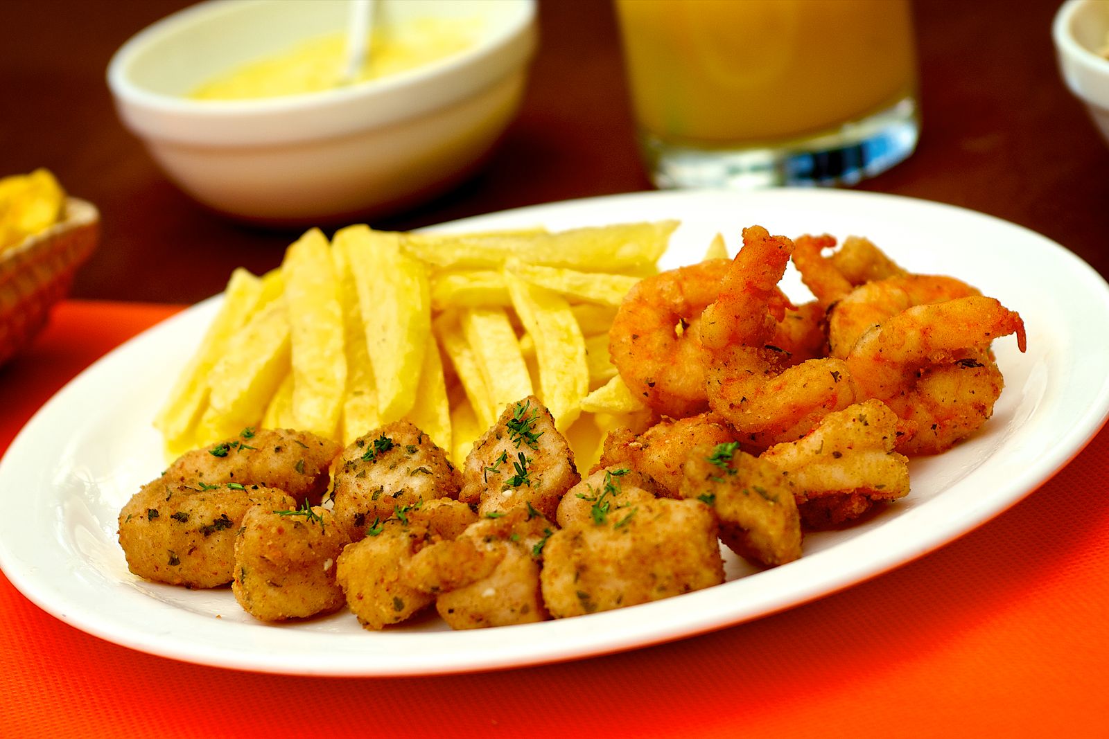 A shared platter of fried shrimp, fish and chips of the kind a sequência arrives in. Photo by DΛVΞ GΛRCIΛ on Pexels.