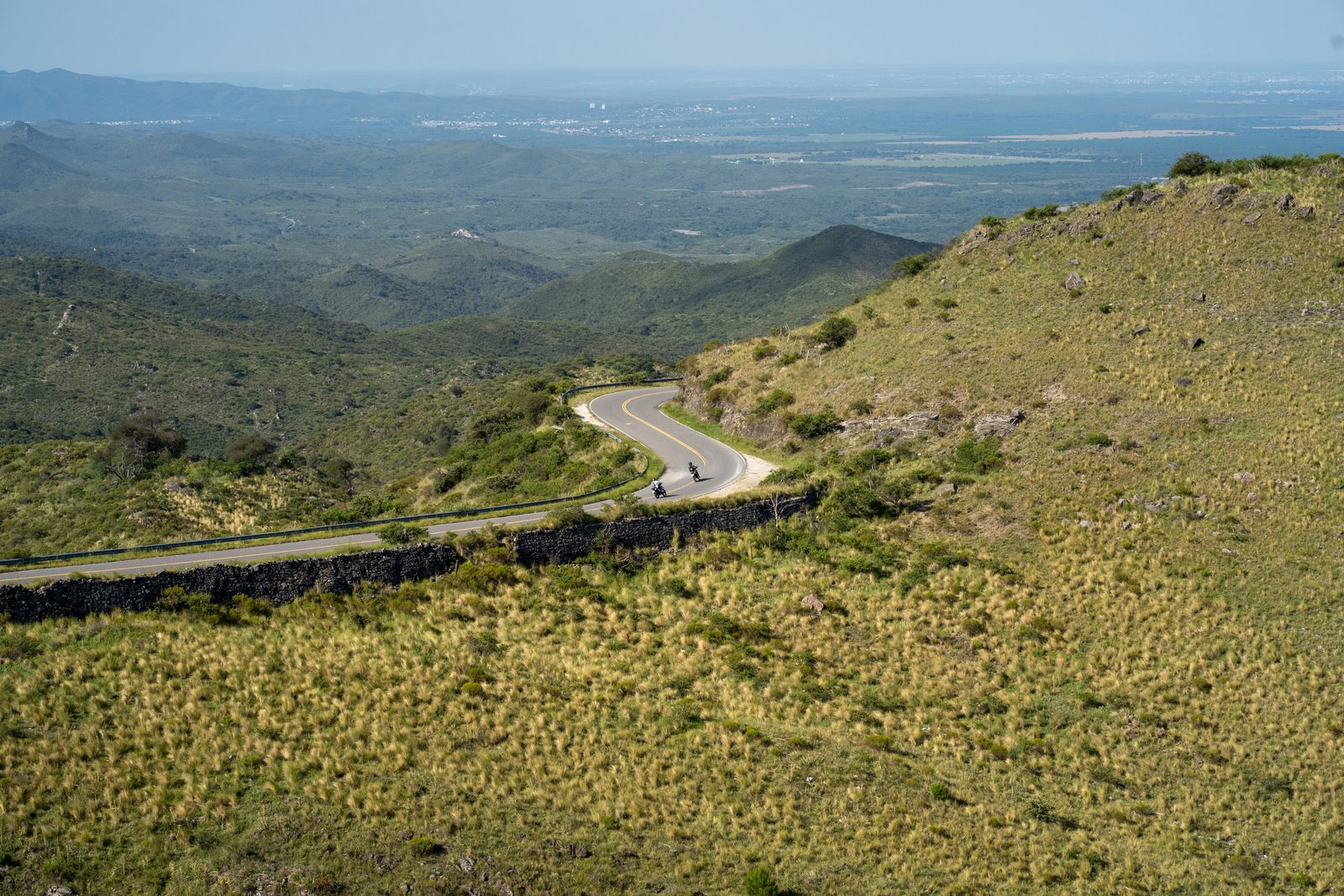 Green hills and a road climbing over the ridge in the Sierras de Córdoba. Photo by Tomás Asurmendi on Pexels.