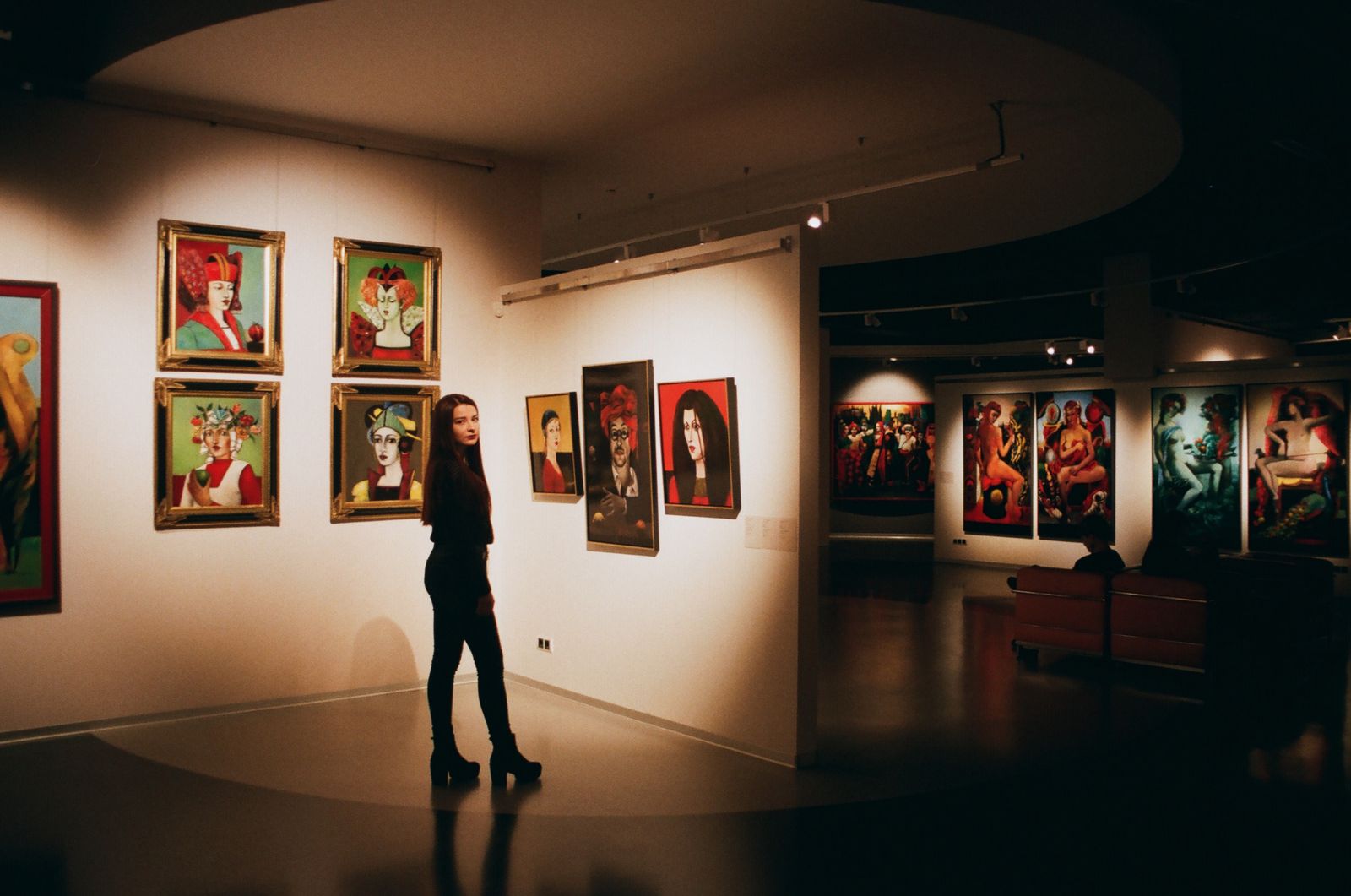 Una persona mirando cuadros enmarcados en una galería. Foto de Darya Sannikova en Pexels.