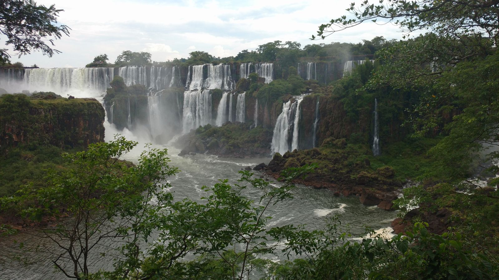 Dozens of separate falls dropping into the gorge, framed by forest. Photo by Rosendo Velarte on Pexels.