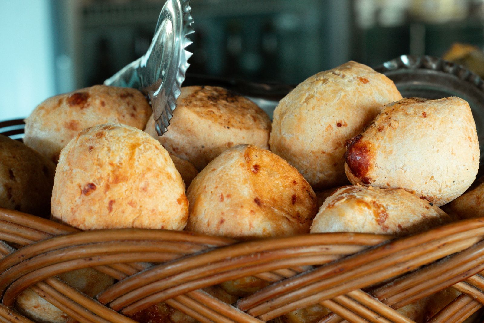 Small warm cheese rolls piled in a wicker basket. Photo by Giovanna Kamimura on Pexels.