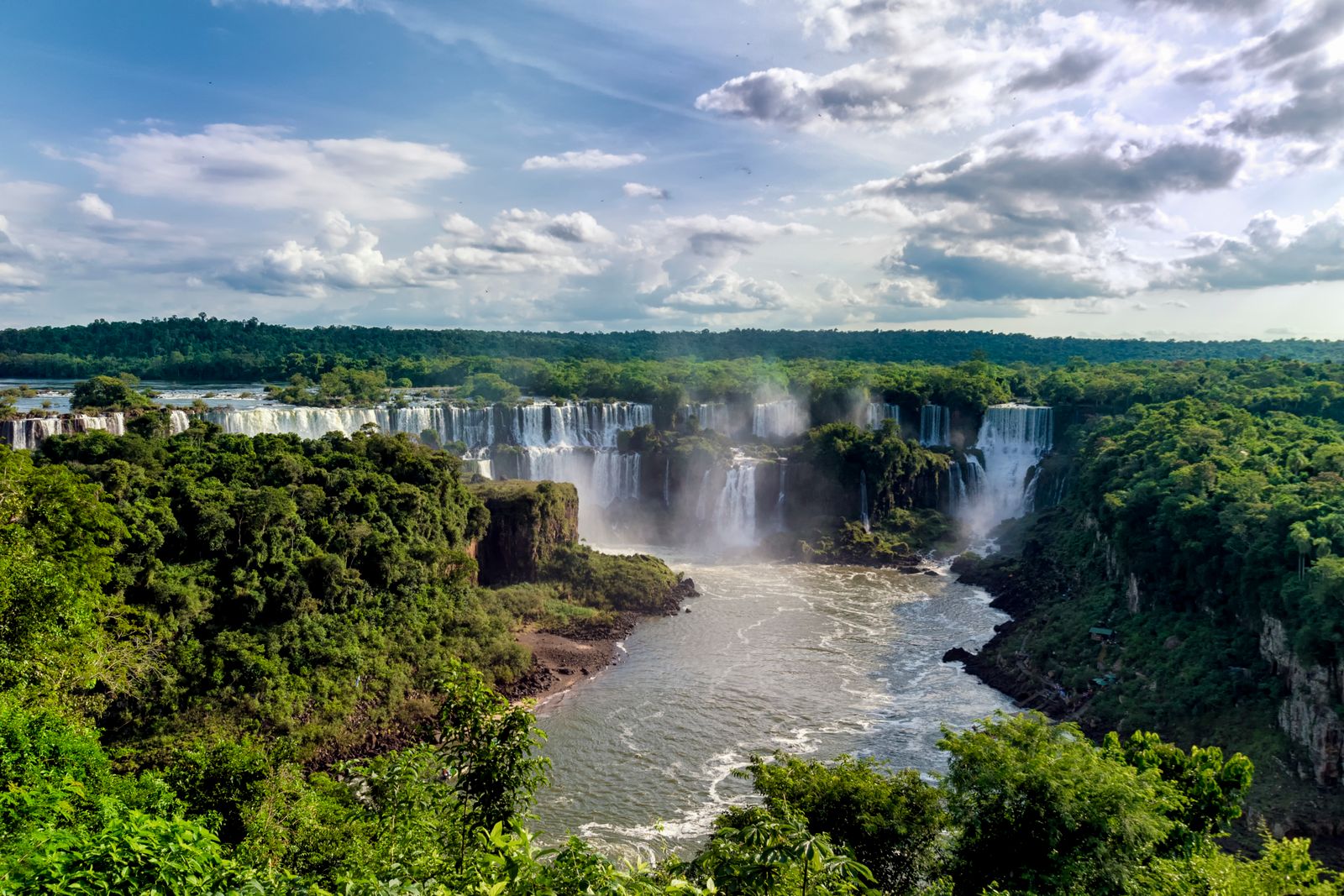 The Iguazú river and the falls seen wide, with jungle on both banks. Photo by Paulo Paranhos on Pexels.