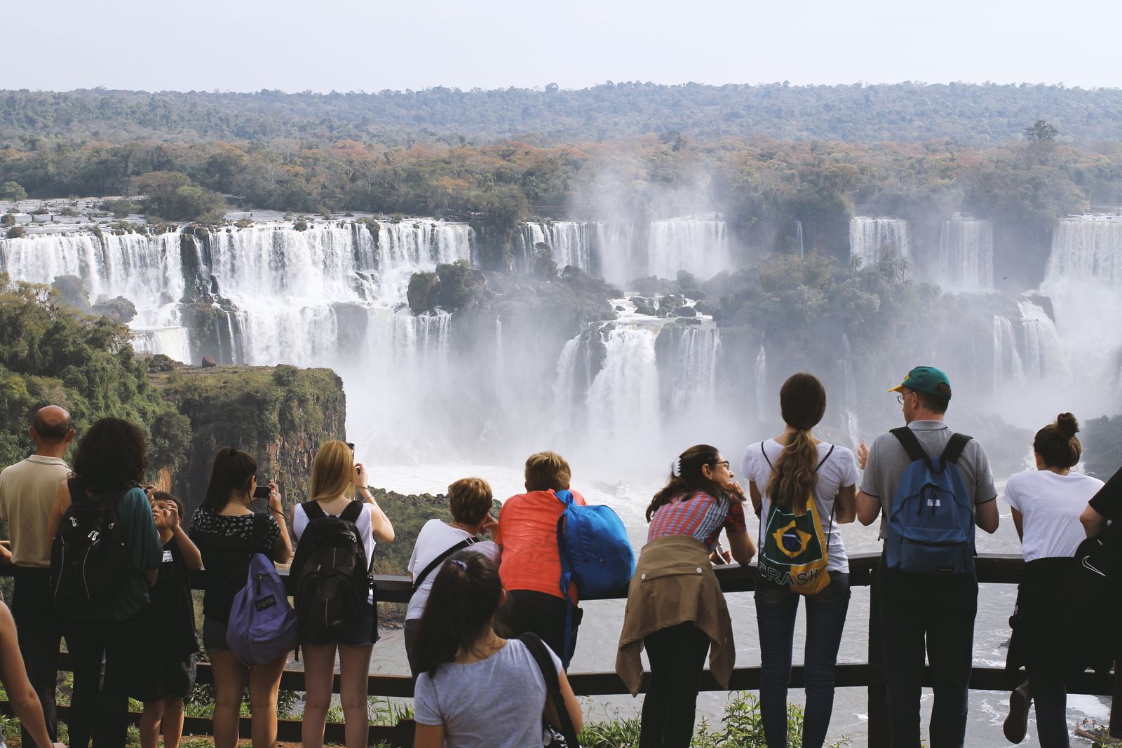 A group at a railing looking out over the full width of the falls. Photo by Jennifer Marchetti on Pexels.