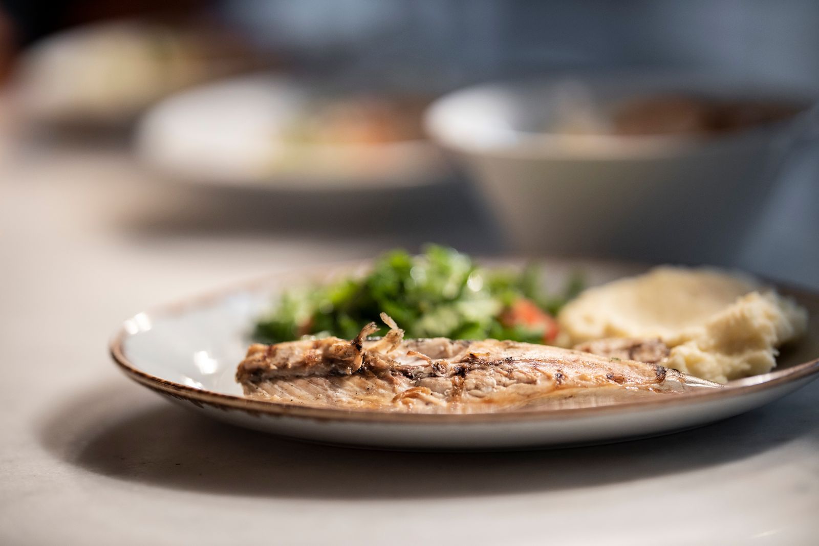 A grilled fish fillet on a plate on a restaurant table. Photo by Engin Akyurt on Pexels.