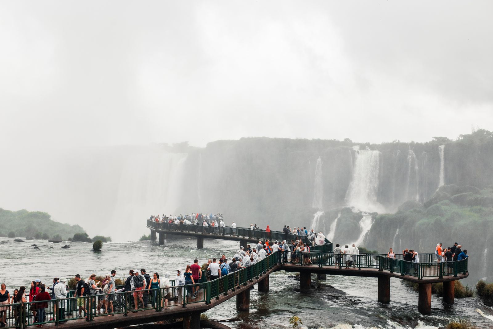 A crowd of visitors on the walkway with the falls behind them. Photo by Manoel Paulo on Pexels.