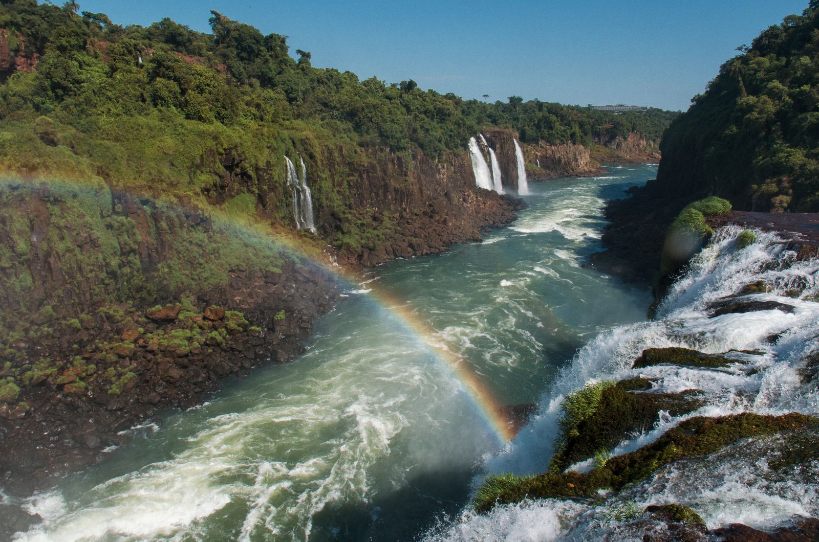 A rainbow arcing over the gorge, seen from the clifftop path. Photo by Cadu Mello on Pexels.