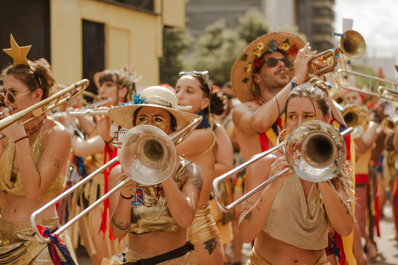 Carnival musicians in costume playing brass instruments in the street. Photo by Maria Luiza Melo on Pexels.