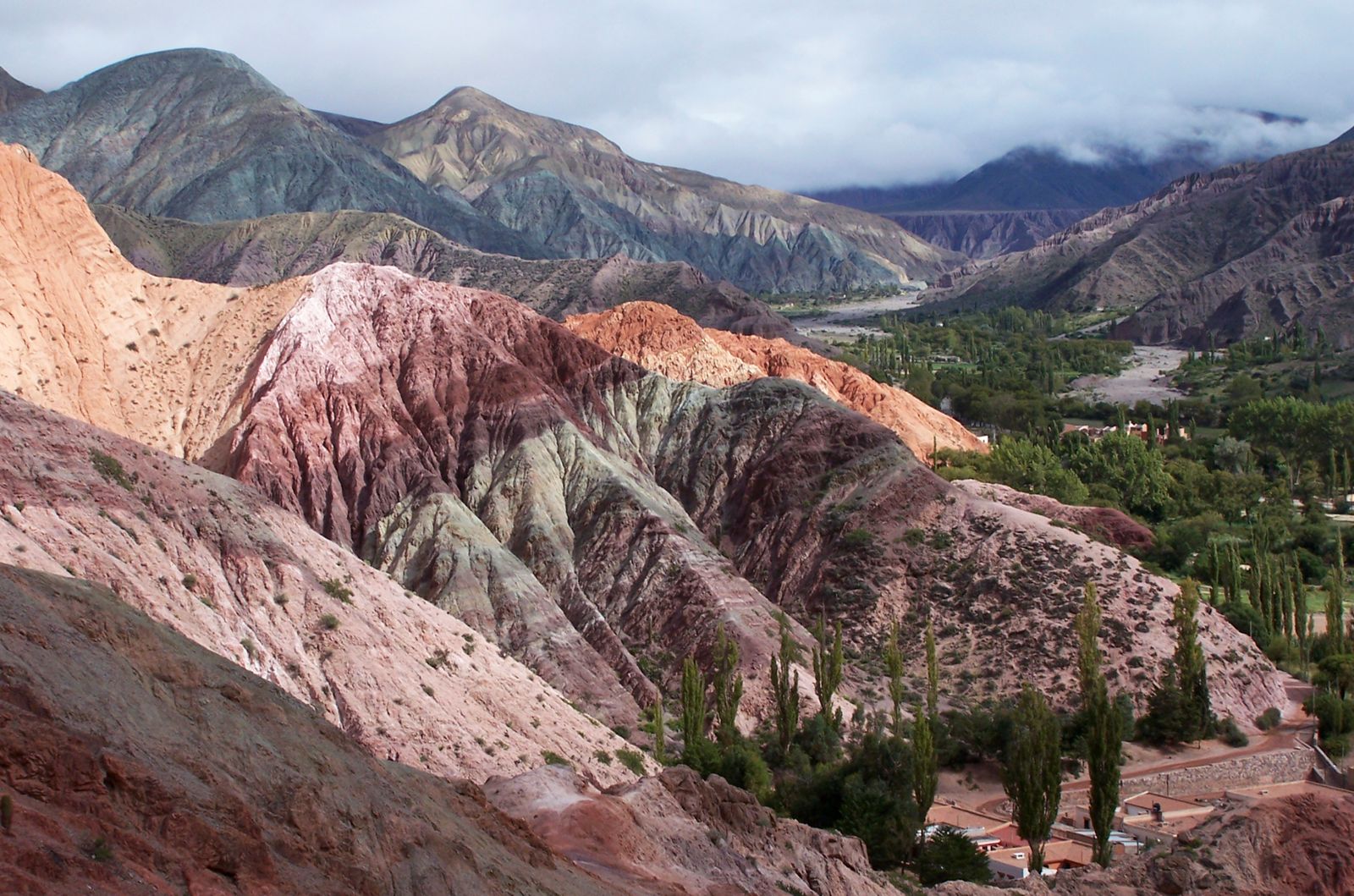 Una loma de roca estratificada roja y rosa sobre un valle verde en la Quebrada. Foto de Tom D'Arby en Pexels.