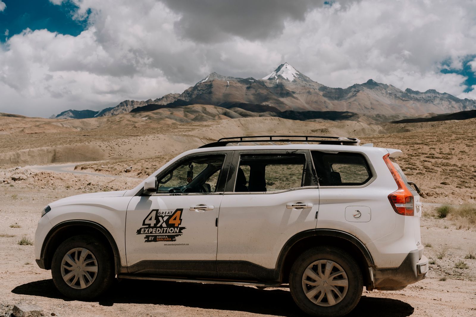 Una camioneta 4x4 estacionada en una planicie seca al pie de las montañas. Foto de Harsh  Kukadiya en Pexels.