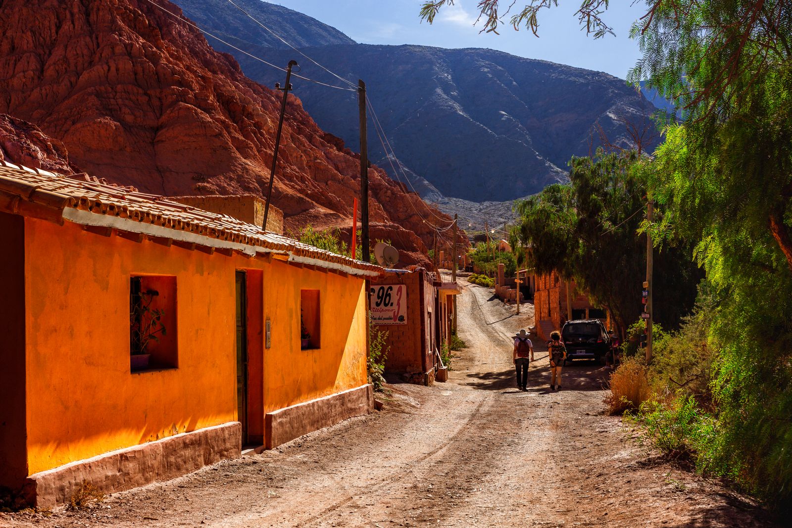 Una casa de adobe ocre en una calle de tierra de un pueblo, al pie de un cerro. Foto de Agustin Devani en Pexels.