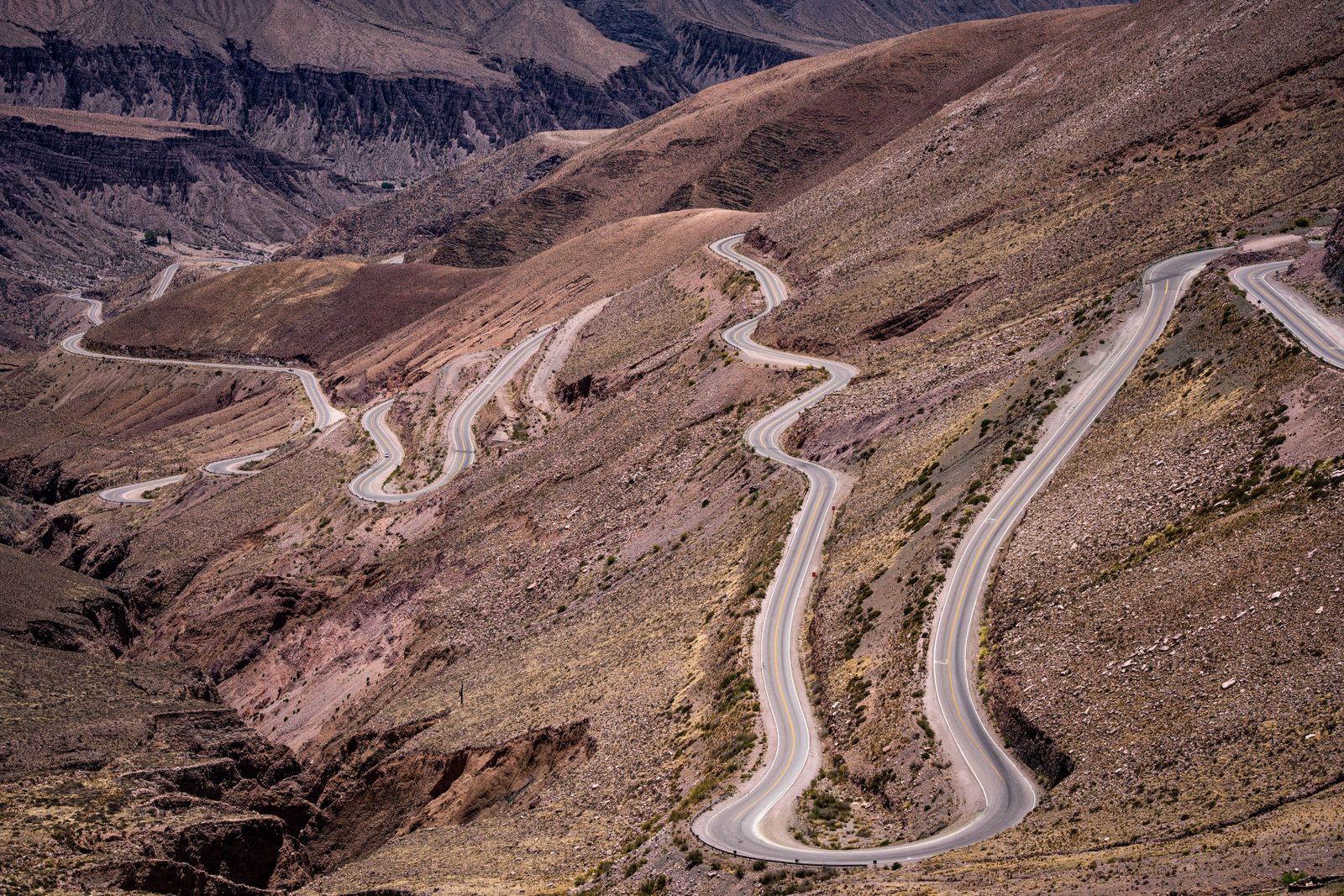 Un camino en zigzag que sube por una ladera pelada de alta montaña. Foto de Diego Girón en Pexels.