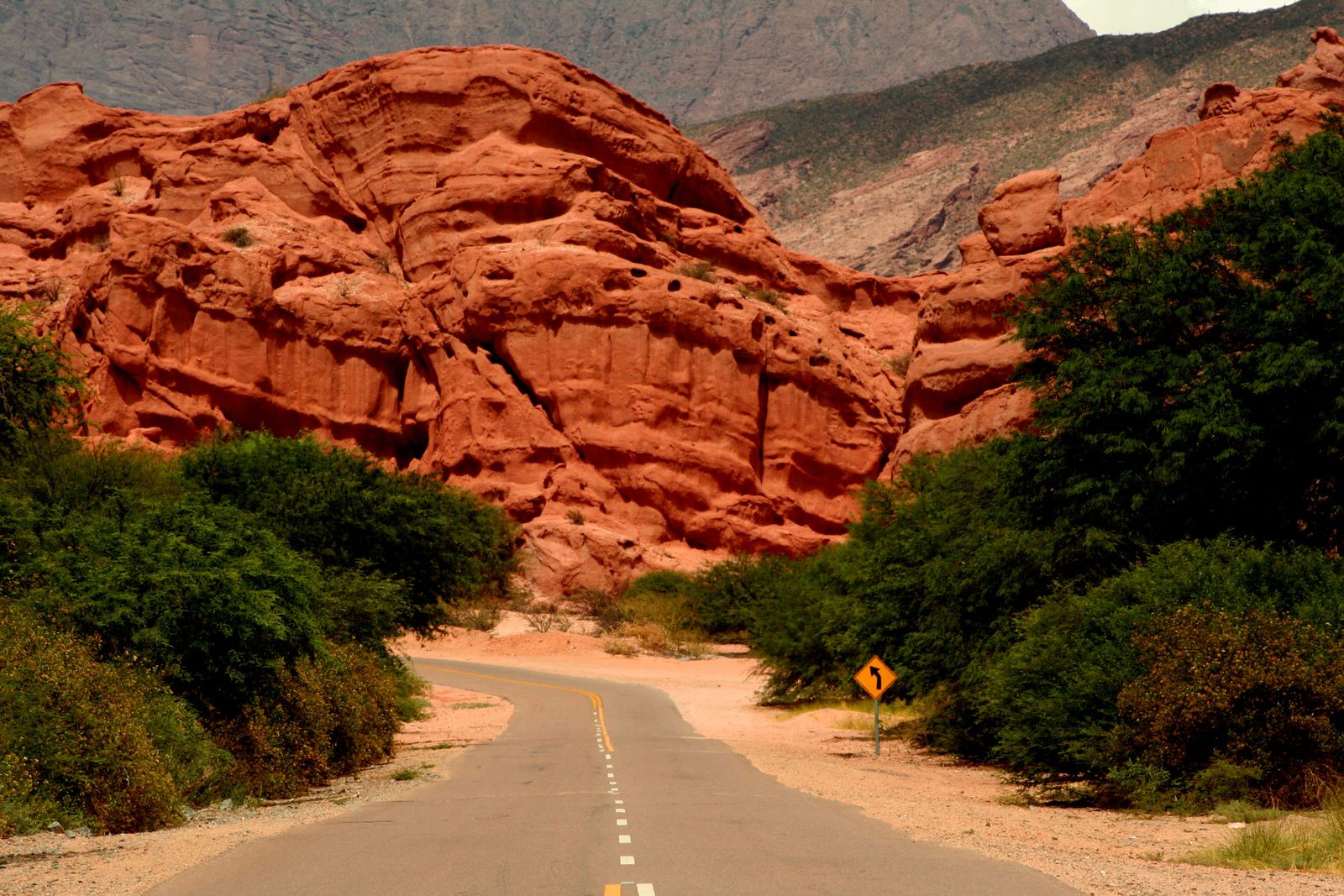 A paved road running between red sandstone formations in the Quebrada de las Conchas. Photo by diego casas on Pexels.