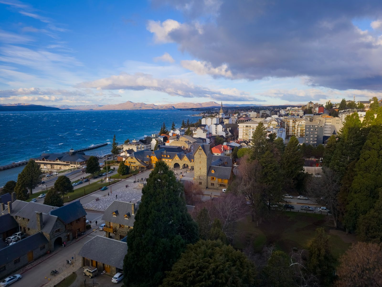 La costanera y los edificios civicos de Bariloche vistos desde el aire, con el lago detras. Foto de Belén Montero en Pexels.