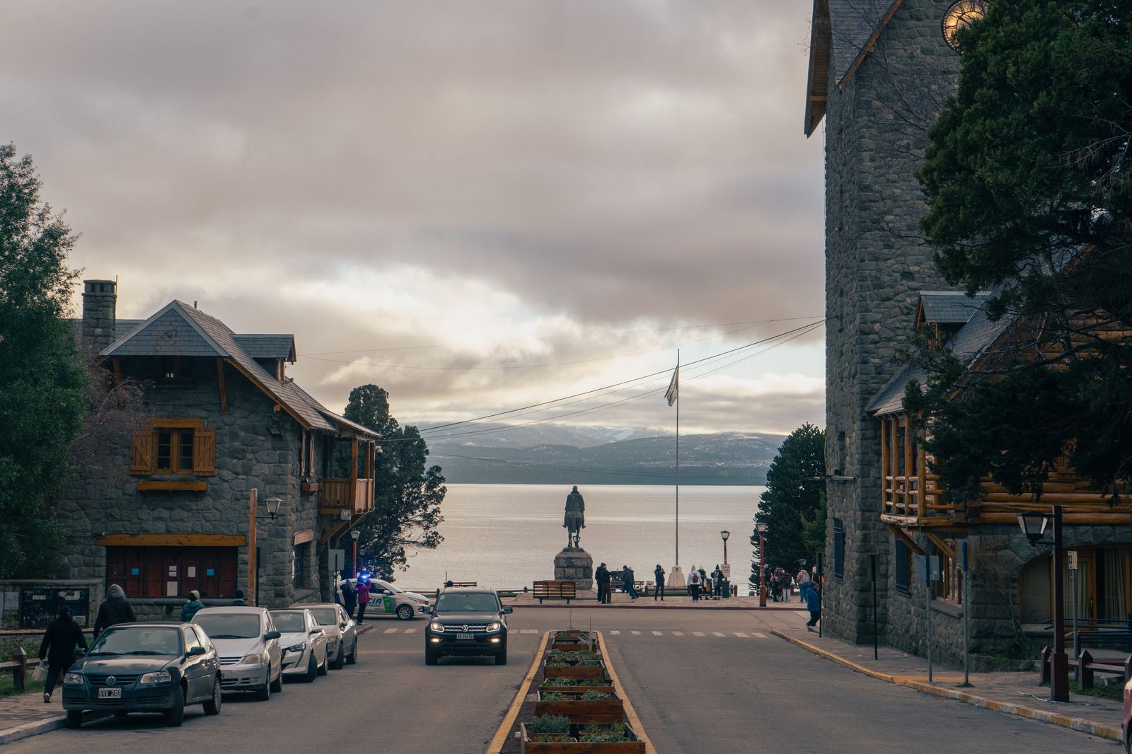 Una calle de Bariloche que baja entre edificios de piedra y madera hacia el lago. Foto de Fernando Hung en Pexels.