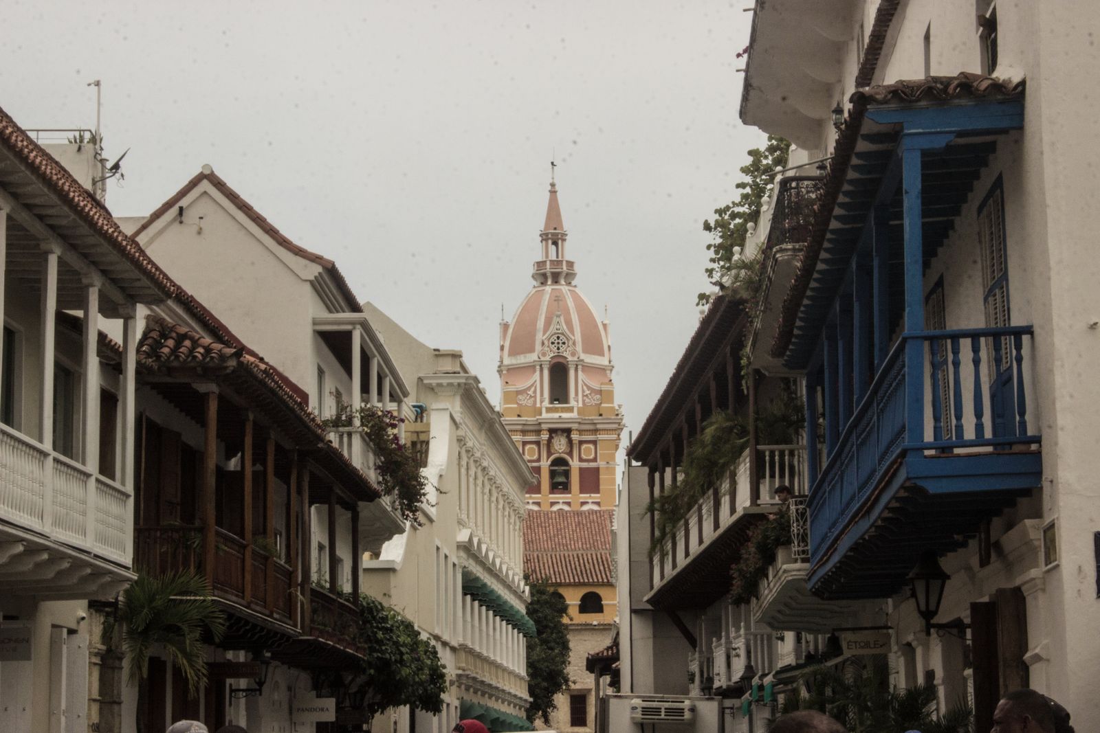 A colonial street of balconied houses in Cartagena, with the cathedral tower behind. Photo by Maria Paula Medina on Pexels.