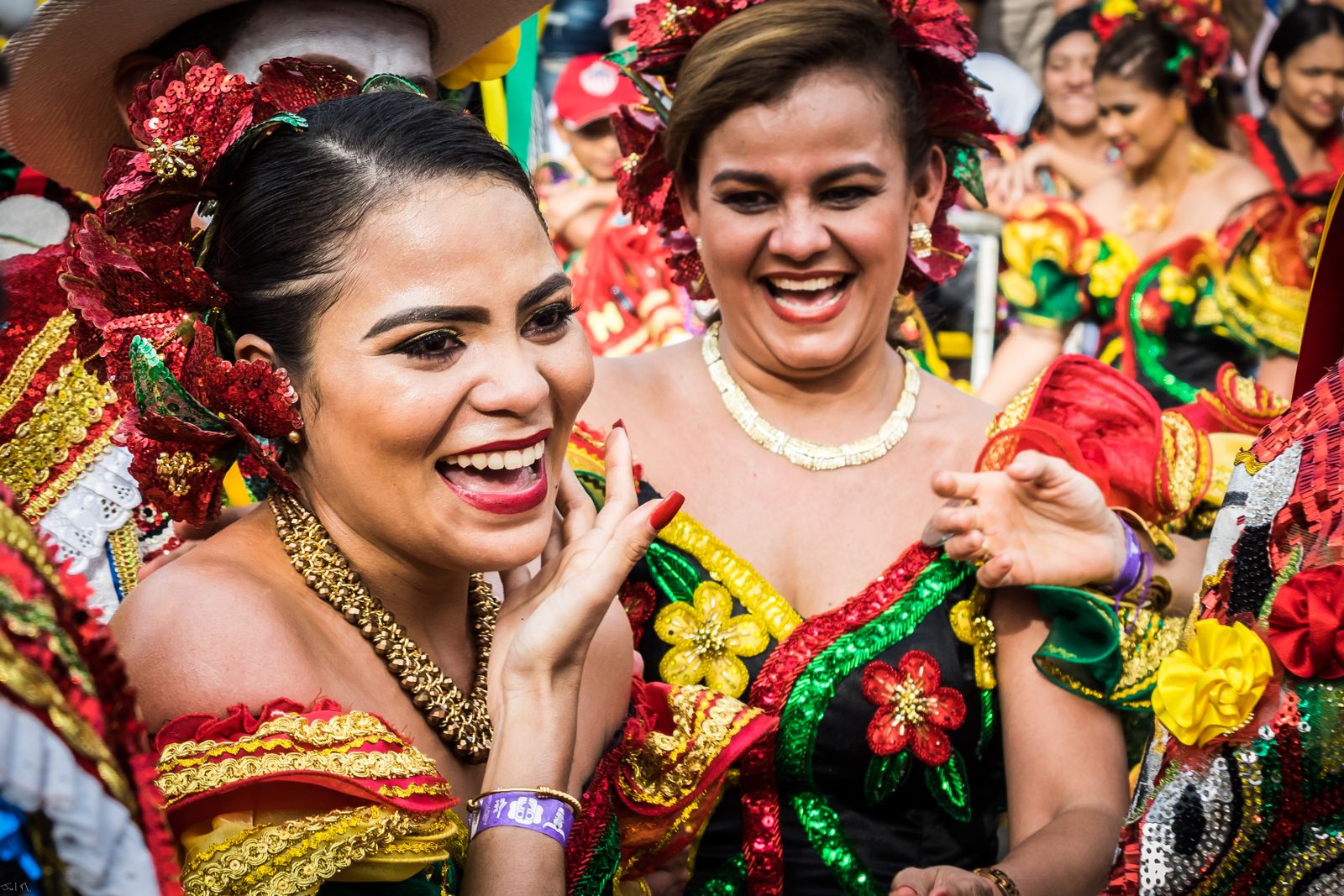 Women laughing in sequinned costume at a street celebration in Colombia. Photo by HERNAN PERNETT on Pexels.