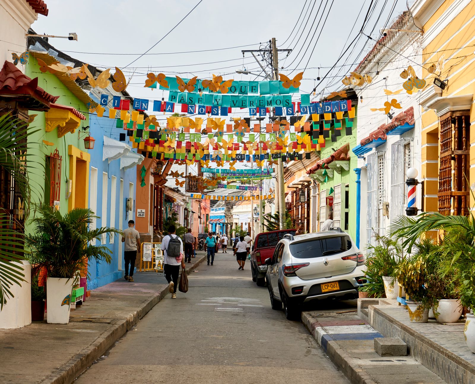 A street in Getsemaní, Cartagena, hung with paper bunting between the houses. Photo by Fer Izaguirre on Pexels.