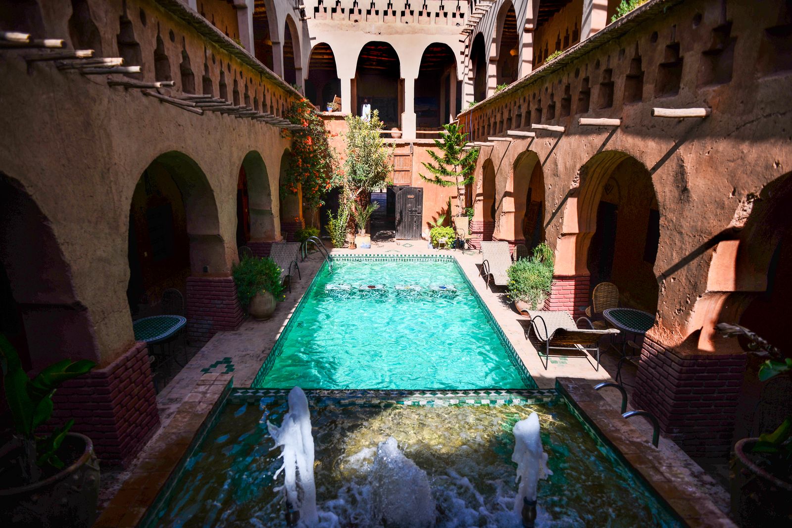 A long pool in the arcaded courtyard of a colonial house. Photo by Andrea Musto on Pexels.