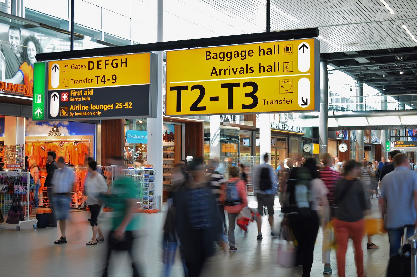 Travellers moving through an airport arrivals hall. Photo by ClickerHappy on Pexels.
