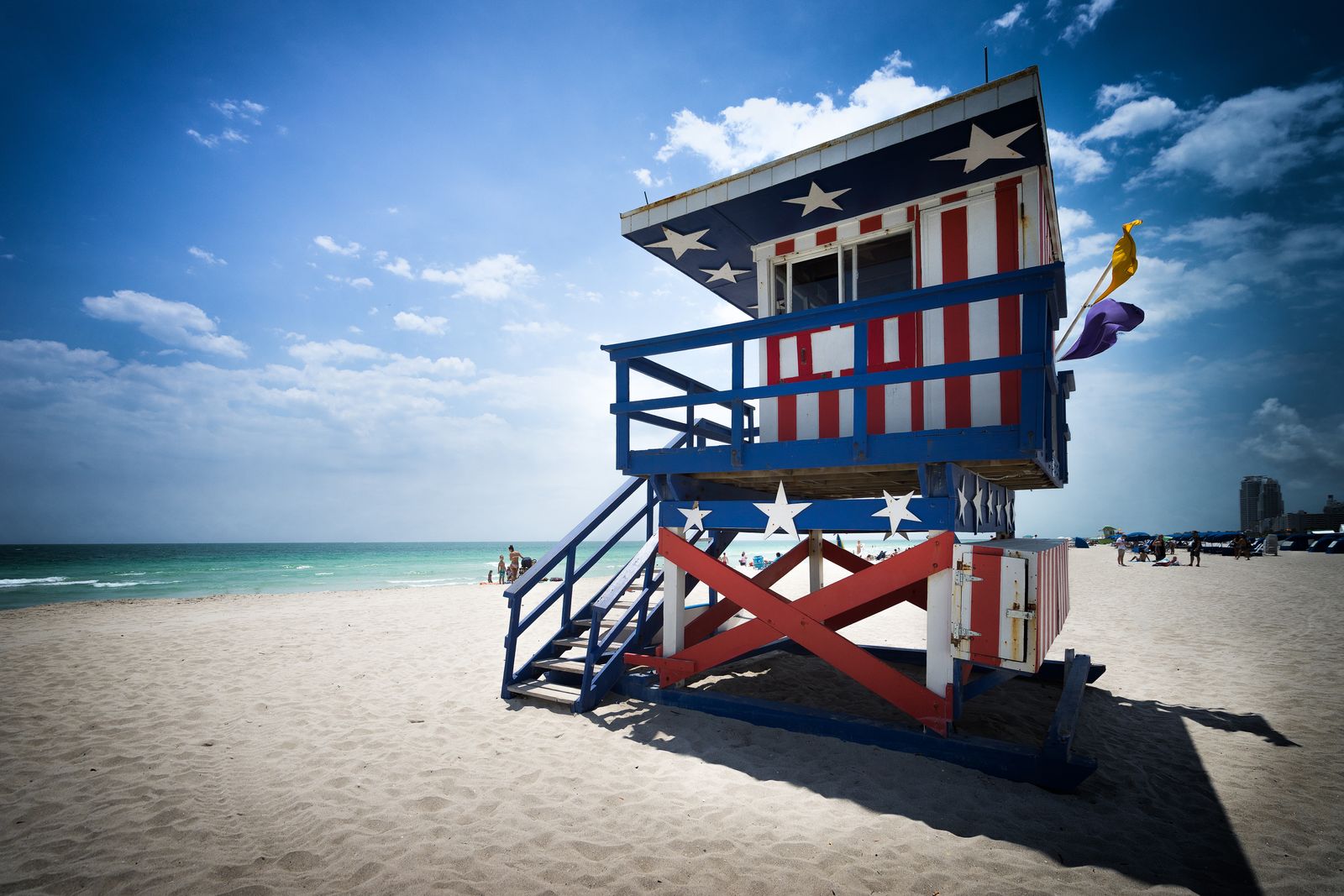 A lifeguard tower painted in stars and stripes on the sand at Miami Beach. Photo by Dominic Müser on Pexels.