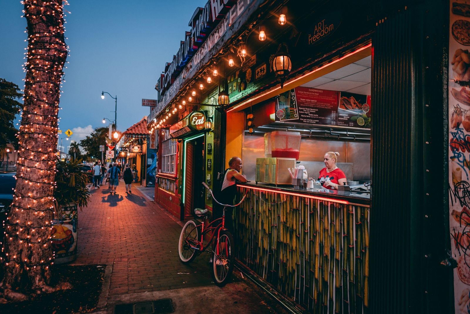 A lit food stall on a busy Miami street in the evening. Photo by Sami Abdullah on Pexels.
