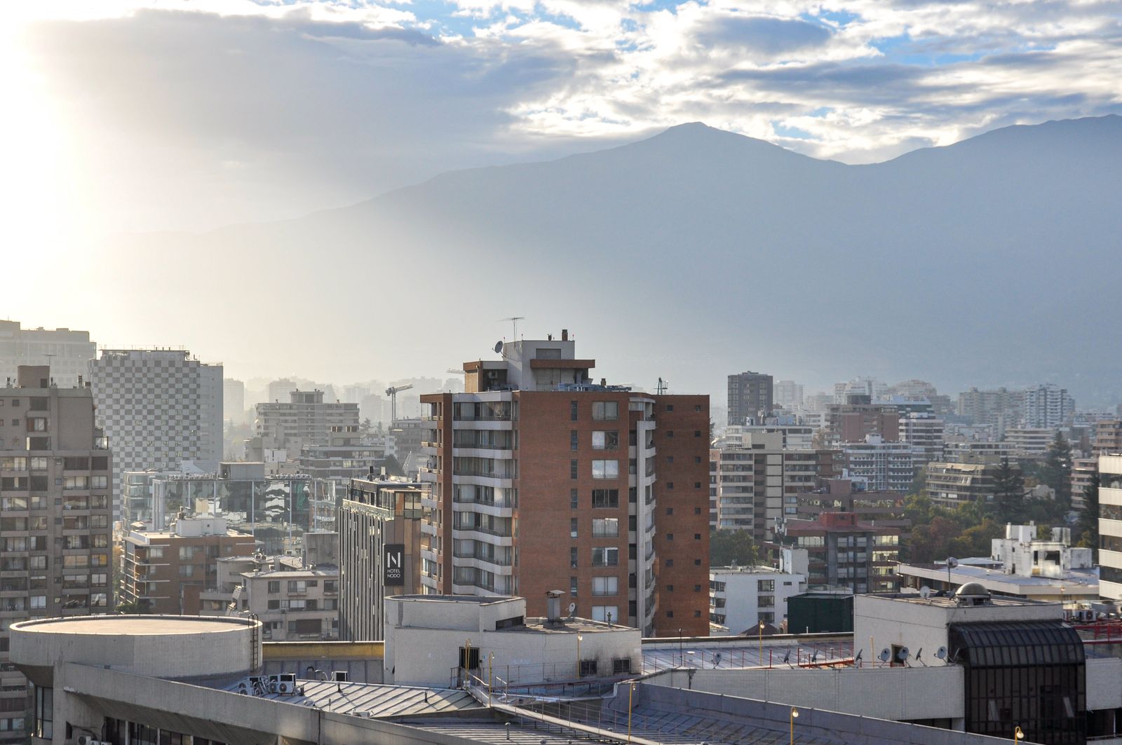 Morning over the rooftops of Santiago with the cordillera behind. Photo by Nikolai Kolosov on Pexels.