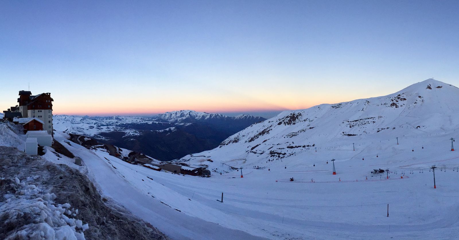Ski runs and lifts on a bare snow-covered mountain above the treeline at dusk. Photo by Daniel Kist on Pexels.