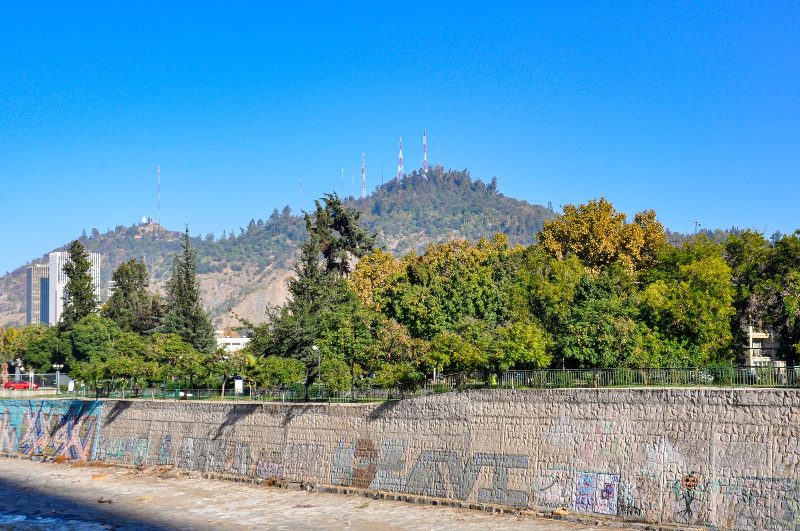 Cerro San Cristóbal rising green out of Santiago under a clear sky. Photo by Nikolai Kolosov on Pexels.