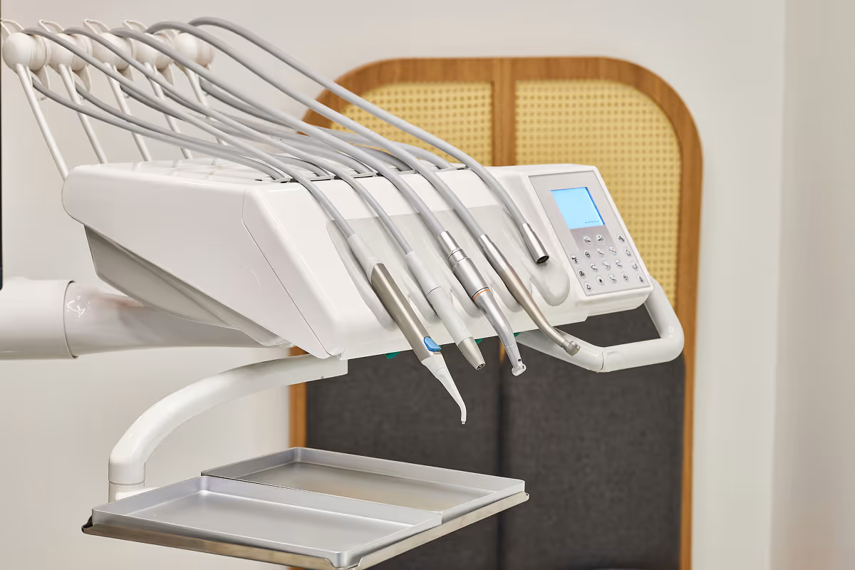 Close-up of dental equipment with multiple attached instruments and digital control panel.