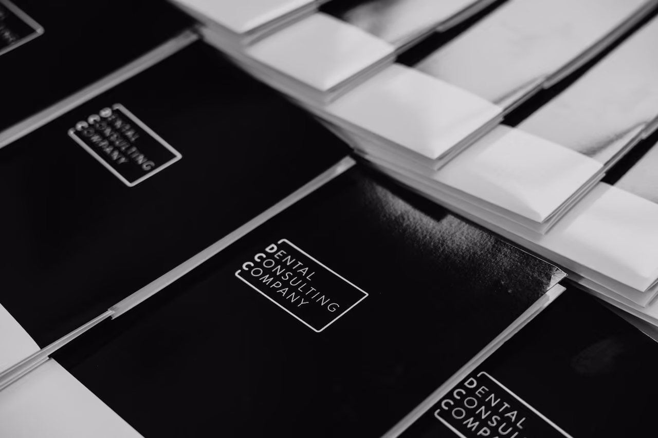 Two people shaking hands over a table with business documents and charts.