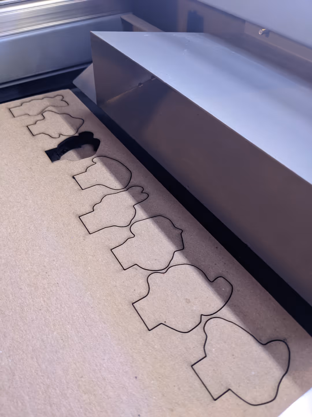 Laser cutting machine creating boardgame pieces for prototype.
