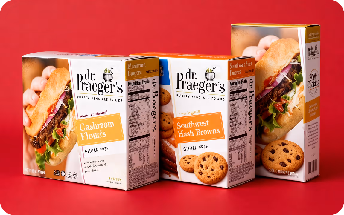 Three Dr. Praeger's gluten free food boxes with a burger and chocolate chip cookies on red background.