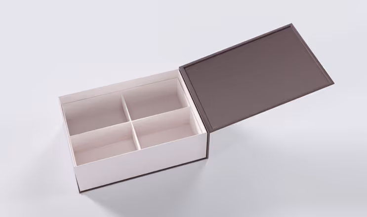 Open rectangular box with four compartments and a detached lid placed beside it on a gray surface.