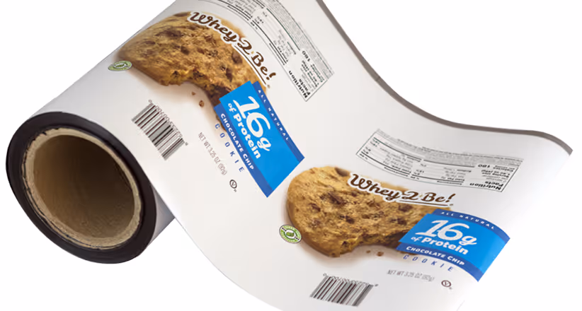 Roll of packaging film showing Whey2Be chocolate chip cookie with 16g protein label and nutrition facts.
