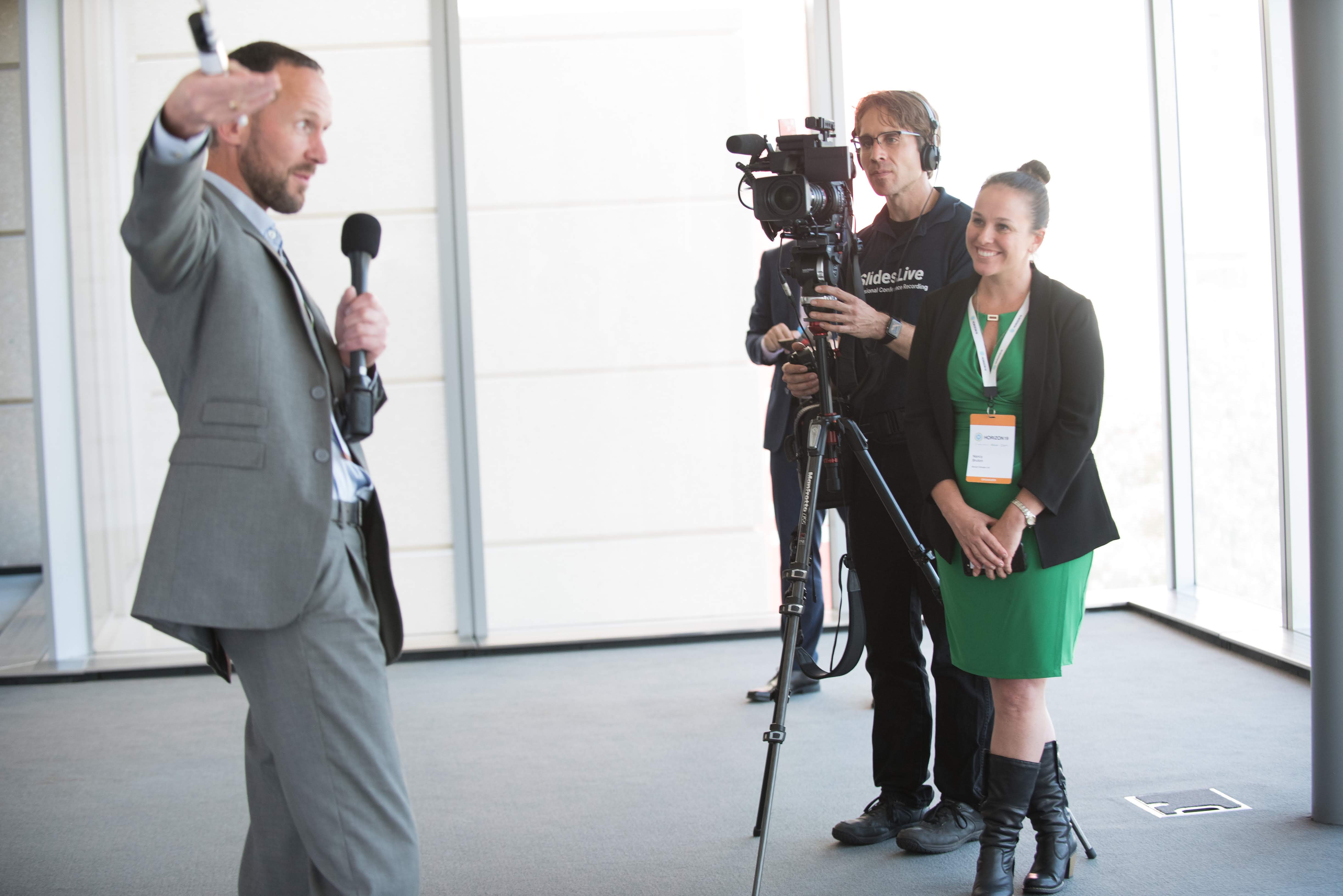 A speaker with a microphone and a camera crew at a World Climate Foundation event.