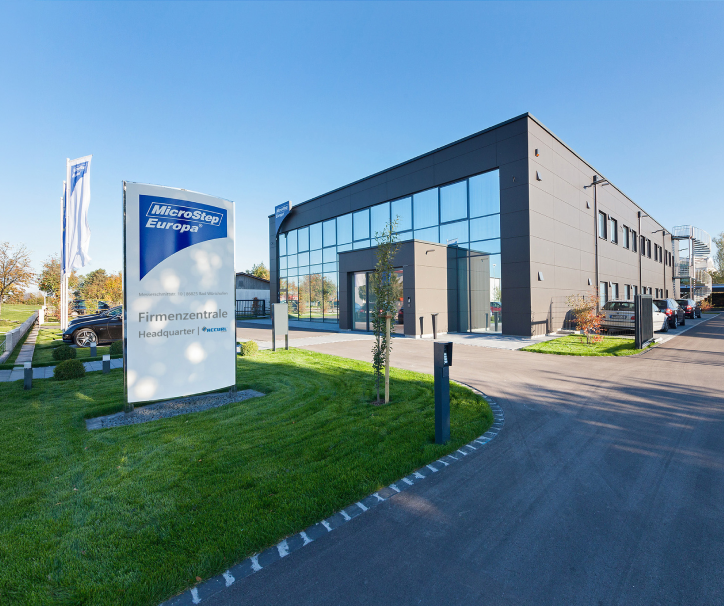 Modern office building with glass windows and a sign reading MicroStep Europa headquarters.