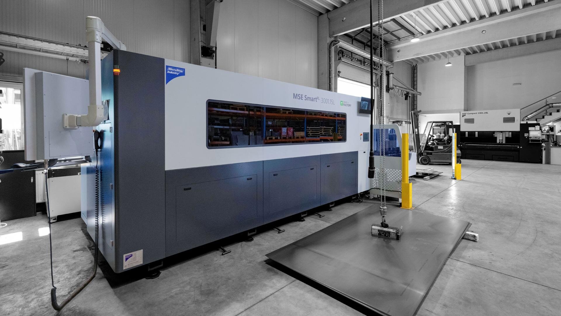 Large industrial machine labeled MSE Smart in a clean factory setting with a metal sheet on the floor.