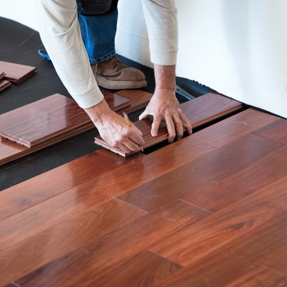 Handwerker verlegt Holzboden während Bodenverlegung in Hamburg