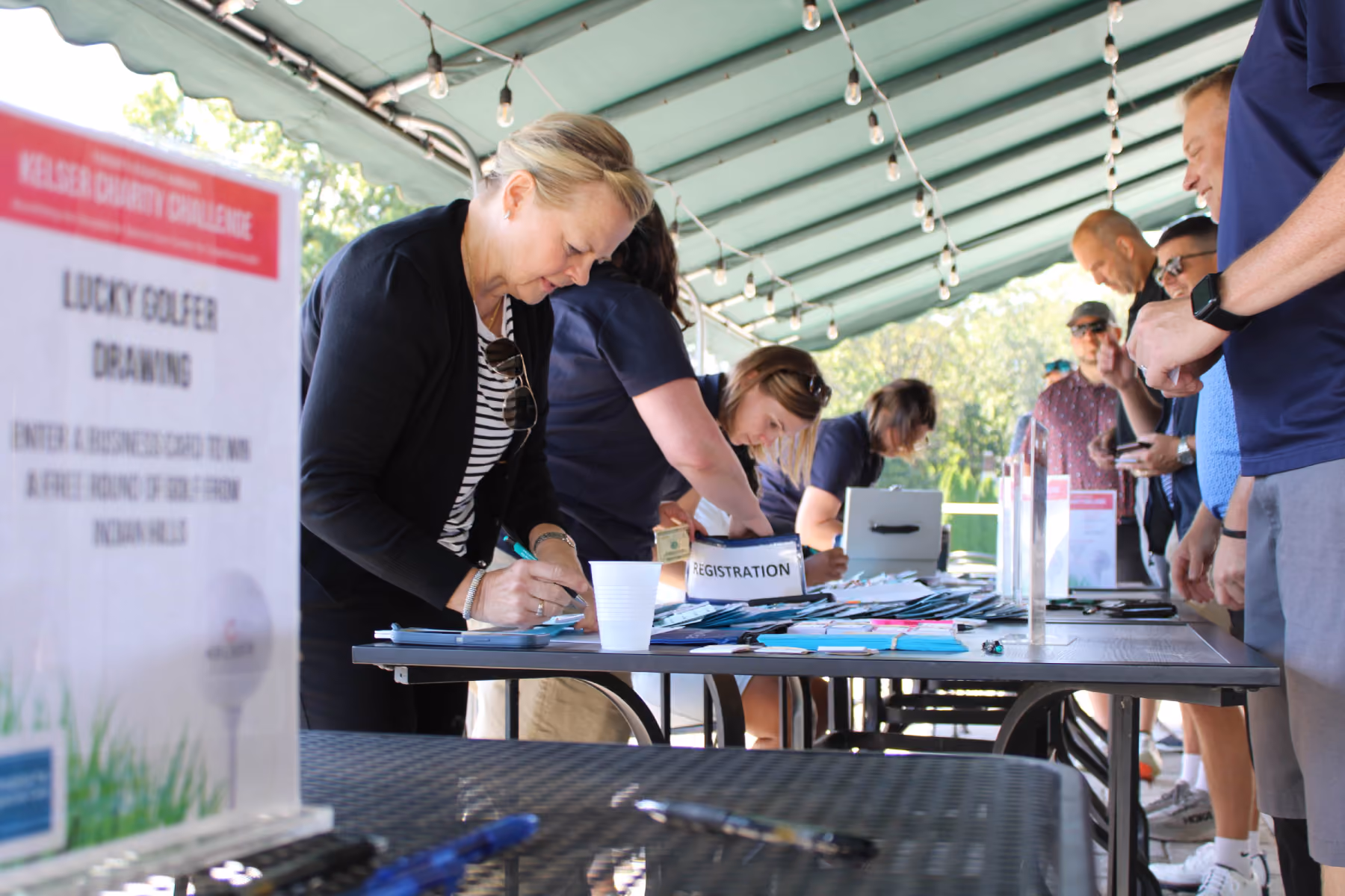 Kelser Charity Challenge golf tournament registration table with attendees signing in at an outdoor event