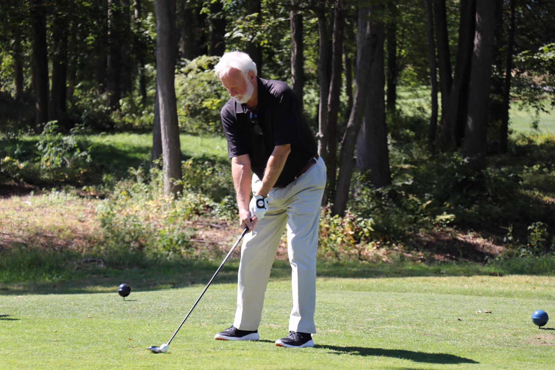 Man playing golf on a sunny course near Glastonbury CT, representing Kelser Corporation's community involvement in local b...