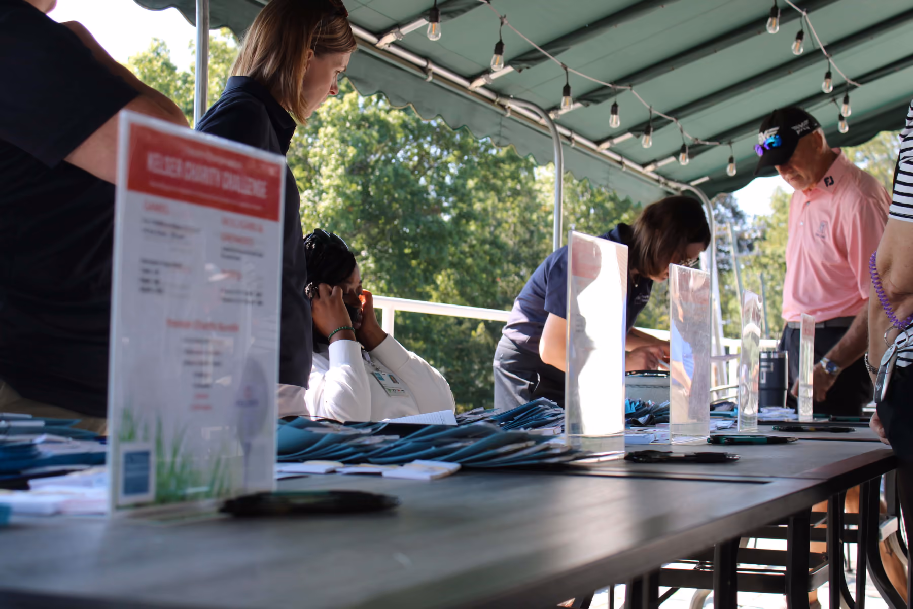 Kelser Corporation staff at registration table during charity challenge event with teal folders and signage