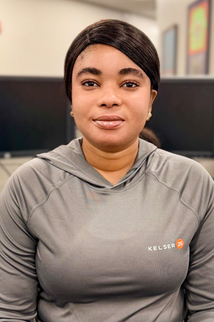 Kelser Corporation IT support team member smiling at office workstation with dual monitors